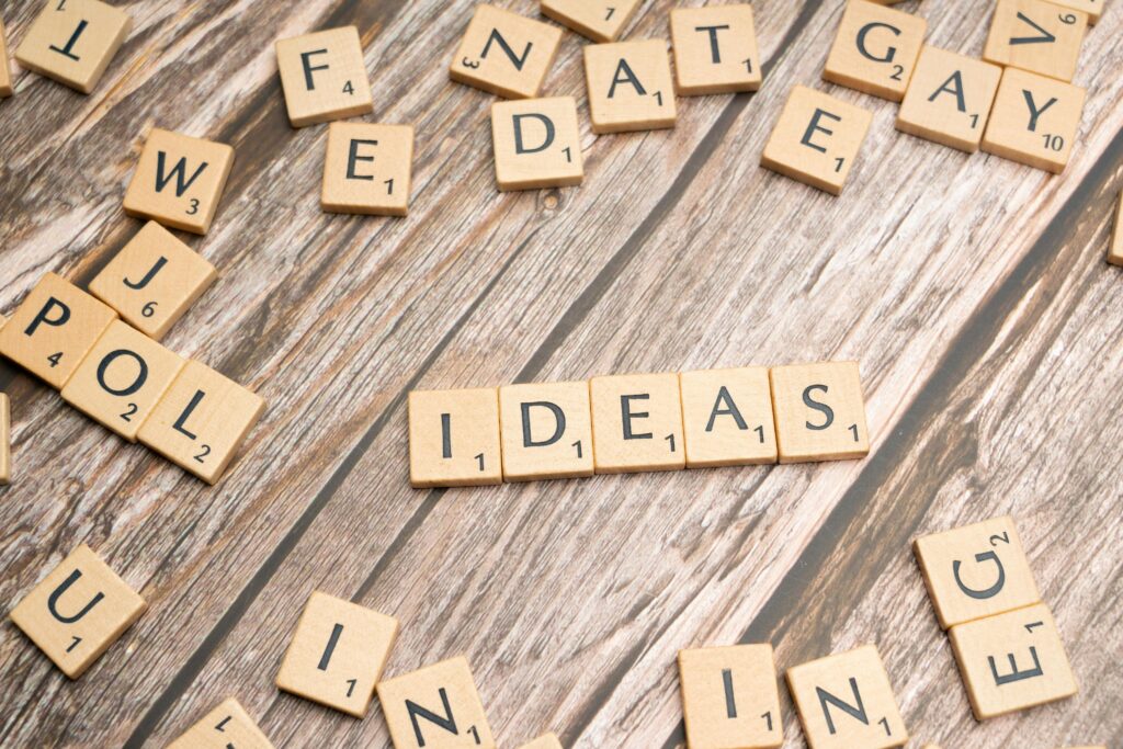 Scrabble word tiles forming 'IDEAS' on a wooden texture background, symbolizing creativity.