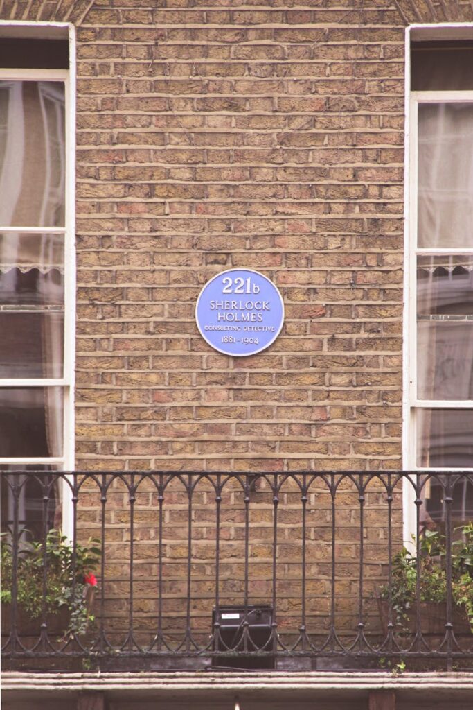 Photo of the iconic Sherlock Holmes plaque on 221B Baker Street brick wall in London.
